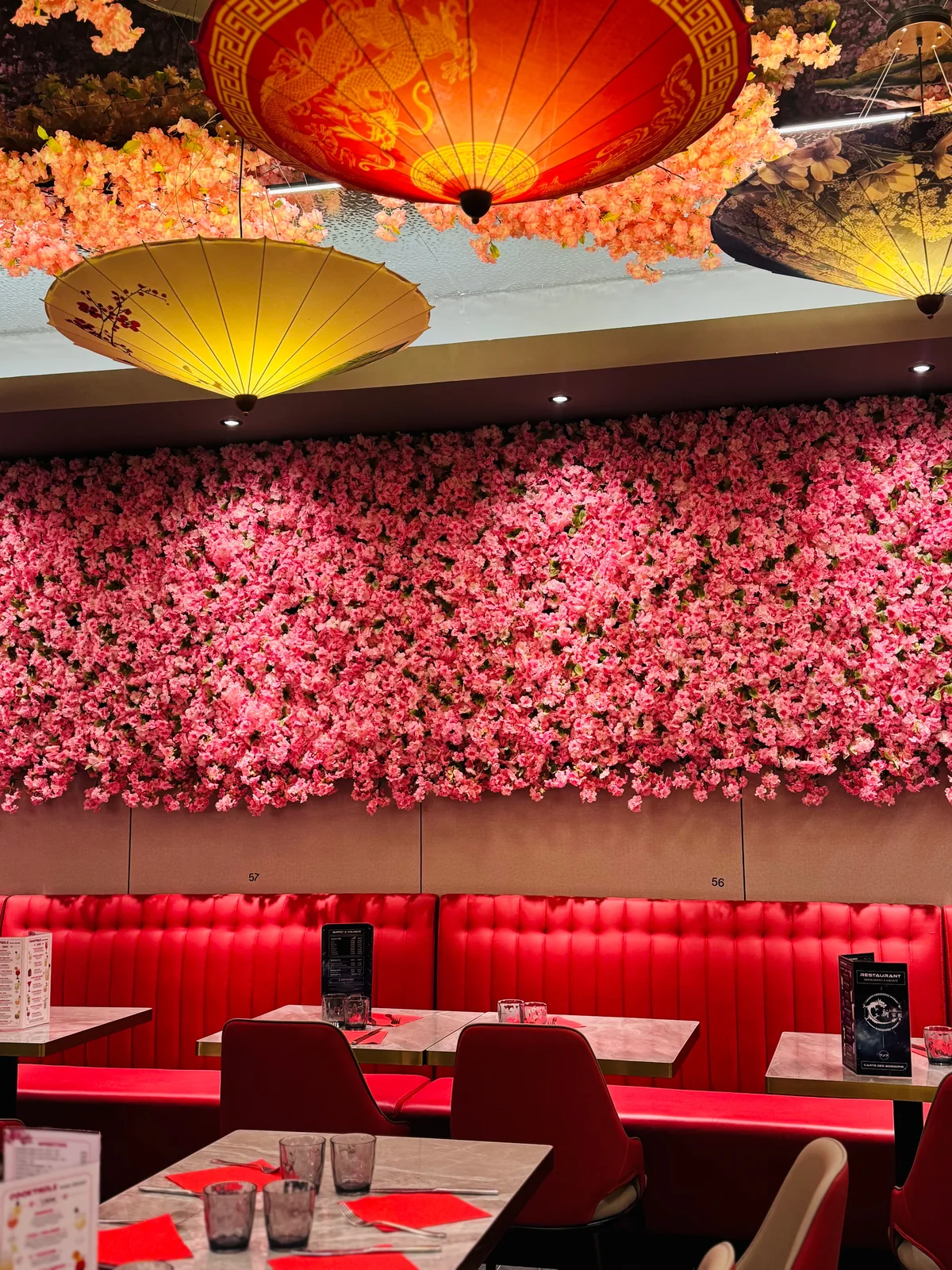 Mur de fleurs de sakura, lanternes rouges et banquettes de la salle