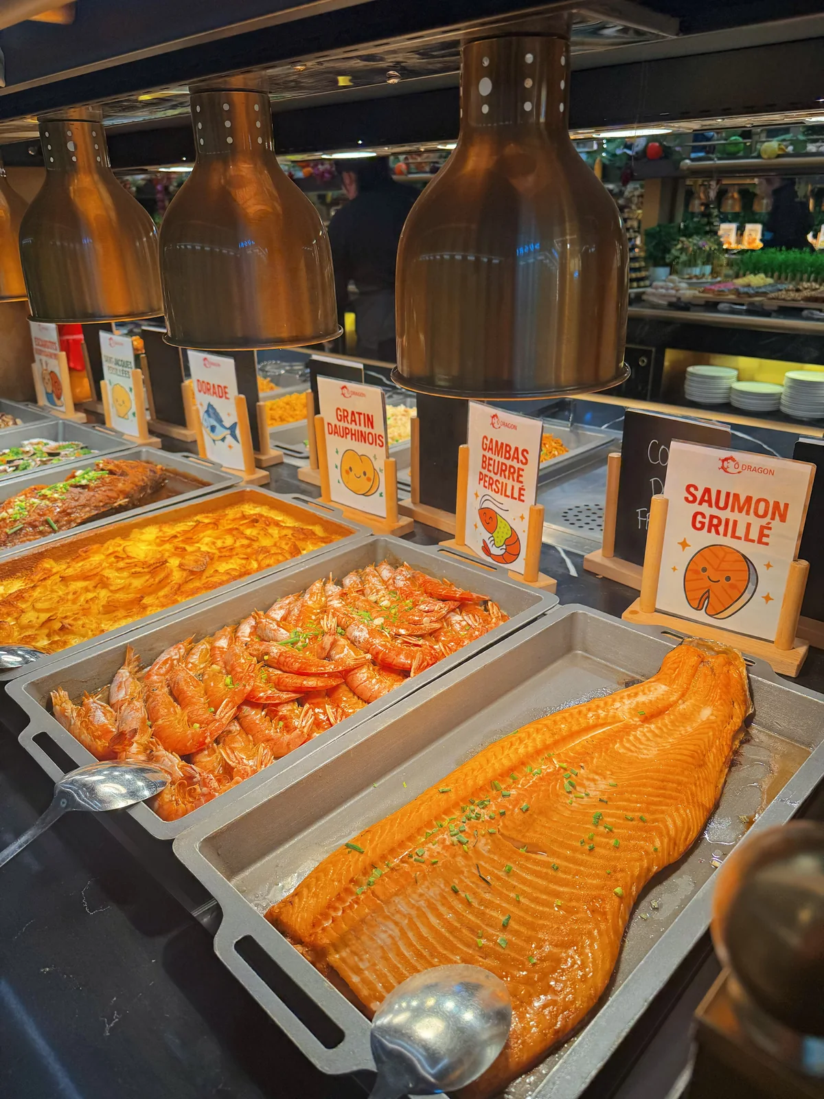 Saumon entier et plats chauds sous les lampes
