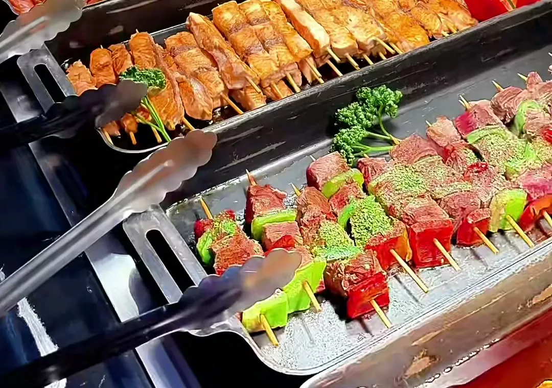 Brochettes grillées sous les lampes de cuivre du buffet chaud